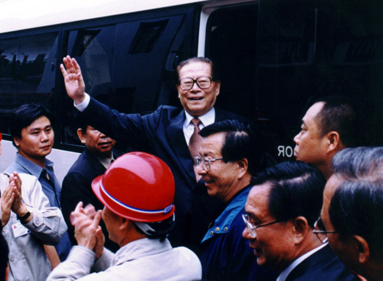 “同志們好！”“大家好！”邁出車門的江澤民向激動(dòng)沸騰的西南鋁職工微笑地點(diǎn)頭，爽朗地問好，親切地?fù)]手致意。（李影攝）