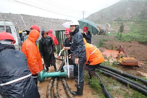 圖一為中州鋁業(yè)保障中心員工冒雨在現(xiàn)場搬運潛水泵設(shè)備，以應(yīng)對未來幾天更加嚴(yán)峻的汛情。